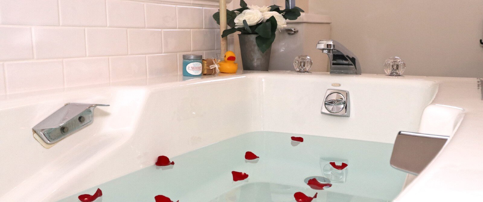 Large jacuzzi tub with red rose petals in the water