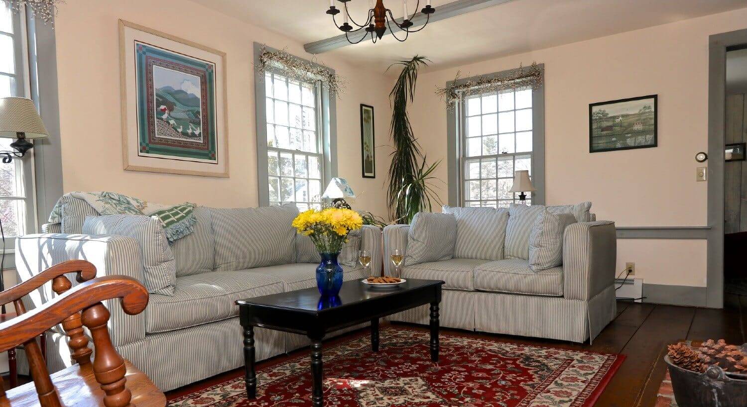 Living room with plush striped couch and love seat, coffee table, and bright windows